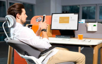 mężczyzna siedzący na nowoczesnym ergonomicznym szaro białymi